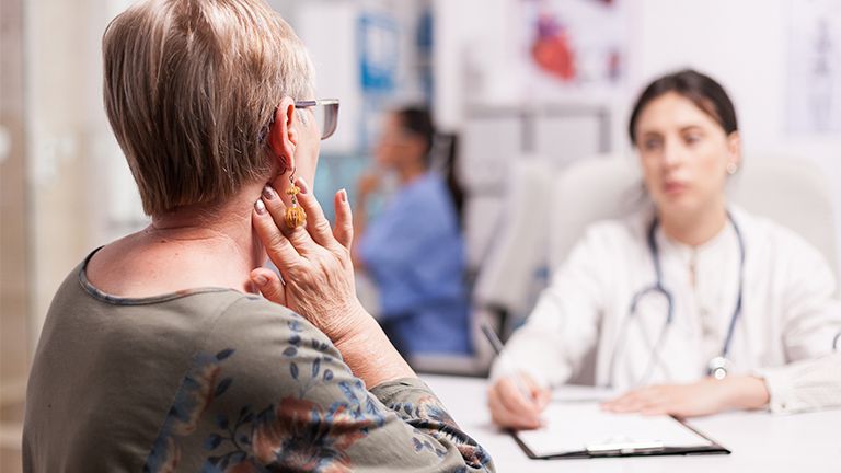Eine Patientin mit Halswirbelsyndrom bei ihrer Ärztin